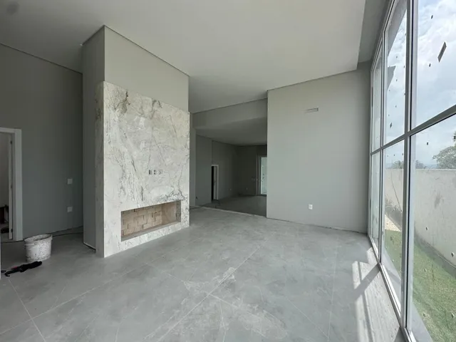 Sala ampla com parede de destaque e grande janela de vista para o exterior.