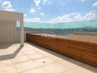 Área externa com piscina e deck de madeira com vista para a paisagem.
