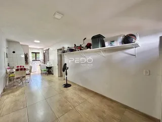 Vista de um corredor interno com piso de cerâmica clara e paredes brancas.