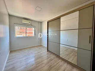Sala de estar com piso de madeira clara e parede cinza.