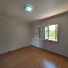 Foto de um cômodo interno com piso de madeira e janela.