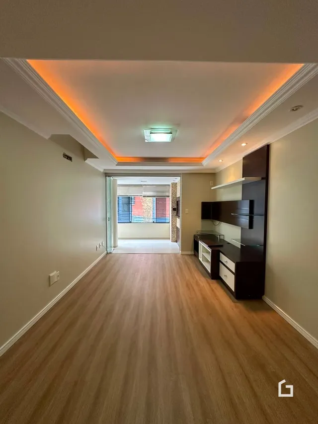 A foto mostra um corredor interno com piso de madeira.