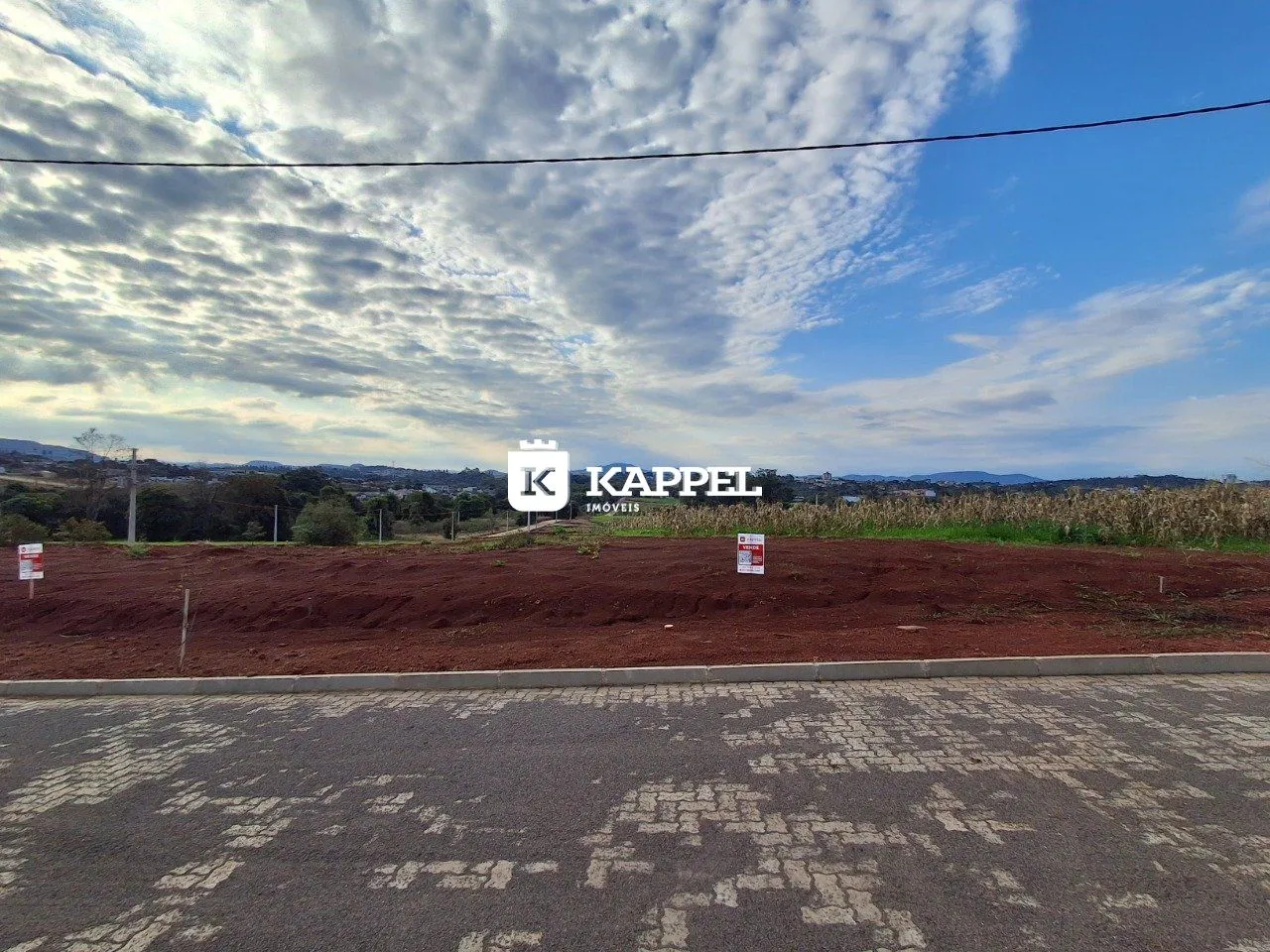 Vista panorâmica da propriedade em Lajeado, mostrando um campo aberto à frente sob um céu nublado.