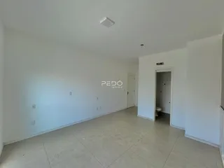 Ambiente interno de uma sala ampla com piso de cerâmica.