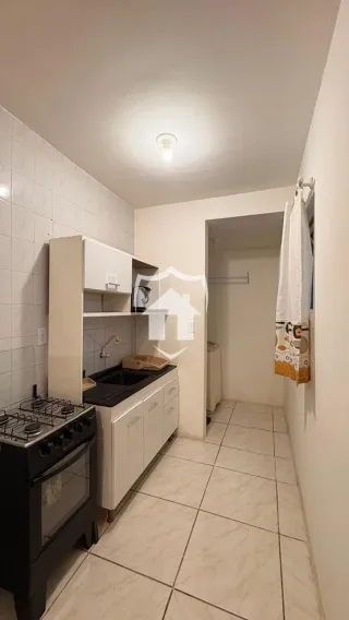 Corredor com paredes brancas e piso de cerâmica claro.