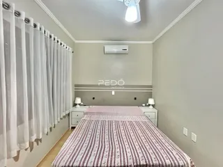 Foto de um quarto com cama e cortinas brancas em um imóvel.