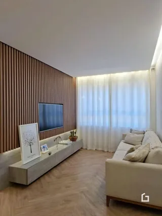 Sala de estar com parede de madeira e piso de madeira clara.