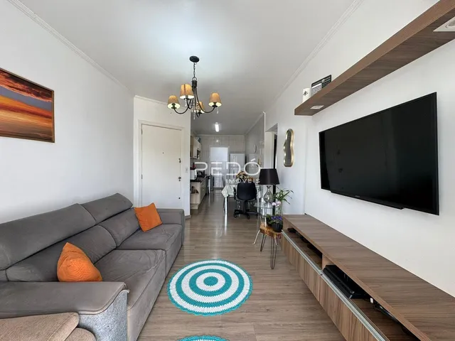 Sala de estar com sofá e televisão em um apartamento no Brasil.