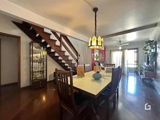 Sala de estar com piso de madeira e escadaria em um imóvel no Brasil.