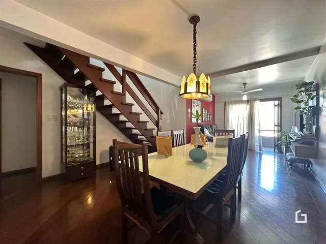 Sala de estar com piso de madeira e escadaria em um imóvel no Brasil.
