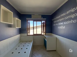 Quarto com paredes azuis e rodapé branco em uma residência.
