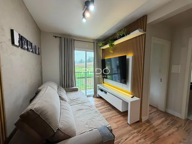 Sala de estar com sofá e vista para o exterior.