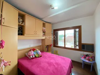 Quarto com armários em madeira e cama rosa.