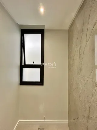Uma parede clara com uma janela escura emoldurada.