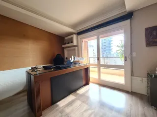 Ambiente interno de uma sala com piso de madeira e porta de vidro.