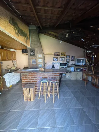 Cozinha com lareira de tijolos e piso de cerâmica.