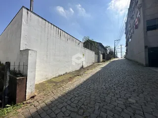 Vista da rua de paralelepípedos entre duas edificações.