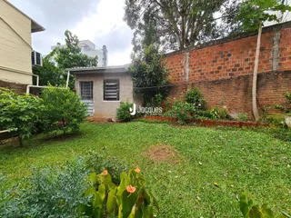 Fachada de uma casa em Lajeado, Brasil com jardim gramado e muro de tijolos.