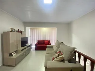 Sala de estar com sofá vermelho e móveis de madeira.
