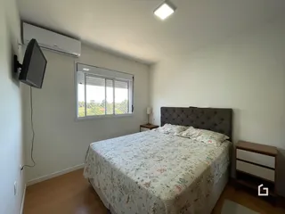 Quarto com janela e cama em ambiente claro.