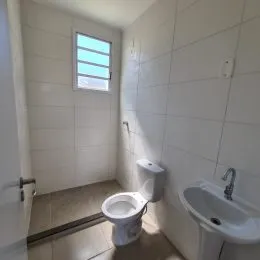 Foto de um banheiro com paredes brancas e piso de cerâmica.