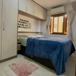 Quarto com cama e armários brancos em um imóvel no Brasil.