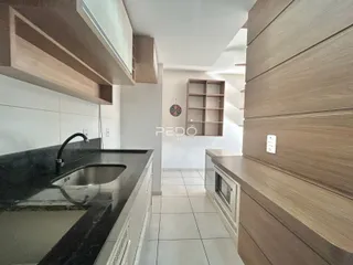 Vista da cozinha moderna com armários e bancada escura.
