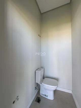 Foto de um corredor interno mostrando um banheiro.