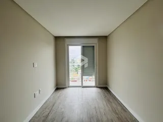 Hall de entrada com piso de madeira clara e porta de vidro.