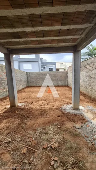Área externa de terra com restos de construção no quintal.