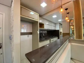 Vista da cozinha moderna com armários brancos e bancadas escuras.