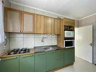 Cozinha com armários de madeira e bancada.