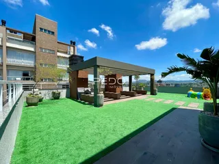 Vista externa de uma residência com jardim e área coberta.