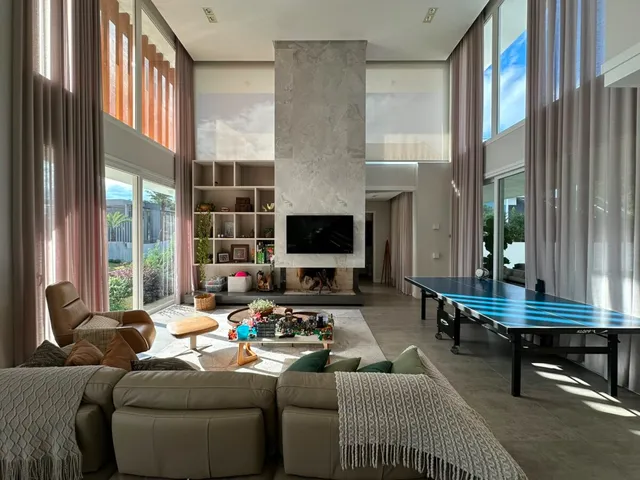 Sala de estar com lareira e grandes janelas em um imóvel.