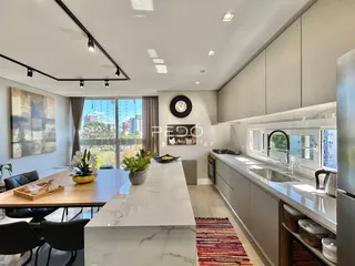 Ambiente moderno de cozinha e sala de jantar com vista para a cidade.