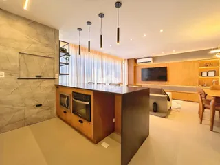 Ambiente moderno com bancada e painéis de madeira em uma residência.