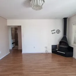 Sala de estar com piso de madeira e lareira.
