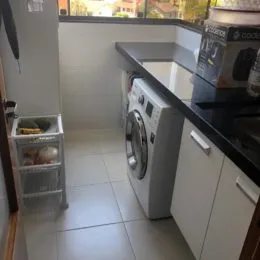 Foto de um ambiente interno com armários e eletrodomésticos brancos.