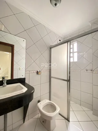 Foto de um banheiro com revestimento de azulejos brancos.