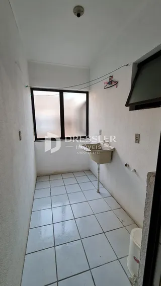 Corredor interno com piso de cerâmica e paredes brancas.