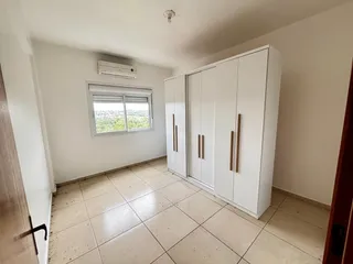 Sala com piso de cerâmica e armários brancos em ambiente claro.