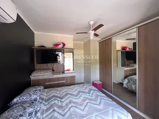 Quarto com cama e armário de madeira em um imóvel no Brasil.