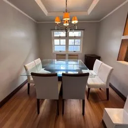 Uma sala de estar com móveis claros e piso de madeira é visível na propriedade.
