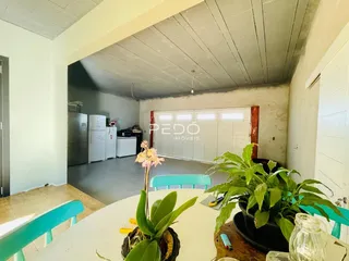 Imagem de uma área interna com teto exposto e acesso a uma garagem.