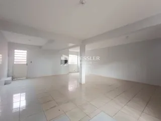 Ambiente interno de uma sala ampla com piso de cerâmica clara.