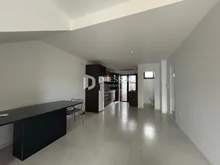 Vista de um corredor interno de uma residência com piso de cerâmica clara.