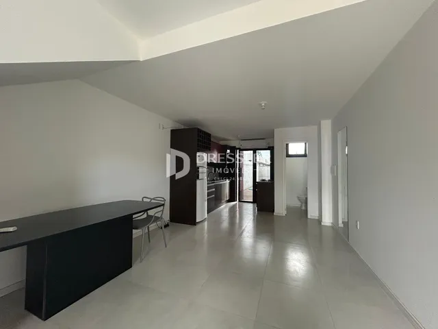 Vista de um corredor interno de uma residência com piso de cerâmica clara.