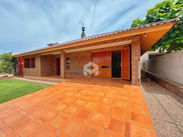 Fachada de casa com telhado de telhas e pátio de tijolos na Lajeado.