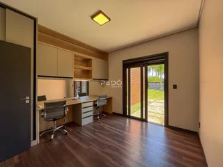 Sala de estar com piso de madeira e cozinha planejada.