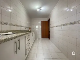Corredor interno com revestimento de cerâmica nas paredes e piso.